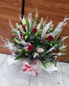  - Handtied of red roses and pink lillies in a box with fillers.