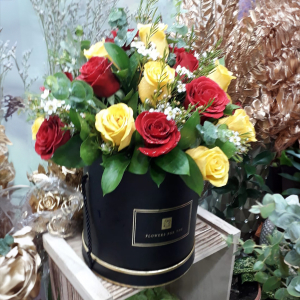  - Hatbox arrangement of red and yellow roses with foliage