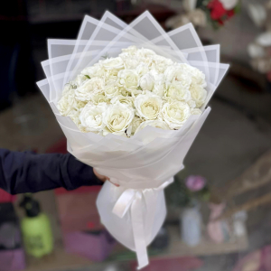  - Bouquet of white roses wrapped and tied with a white ribbon.